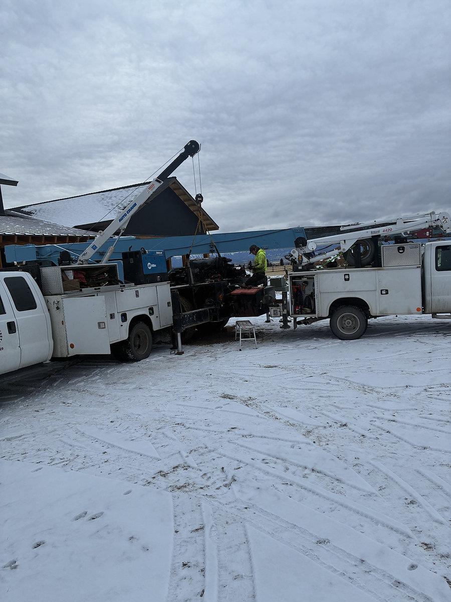 Field service in the snow with two crane trucks