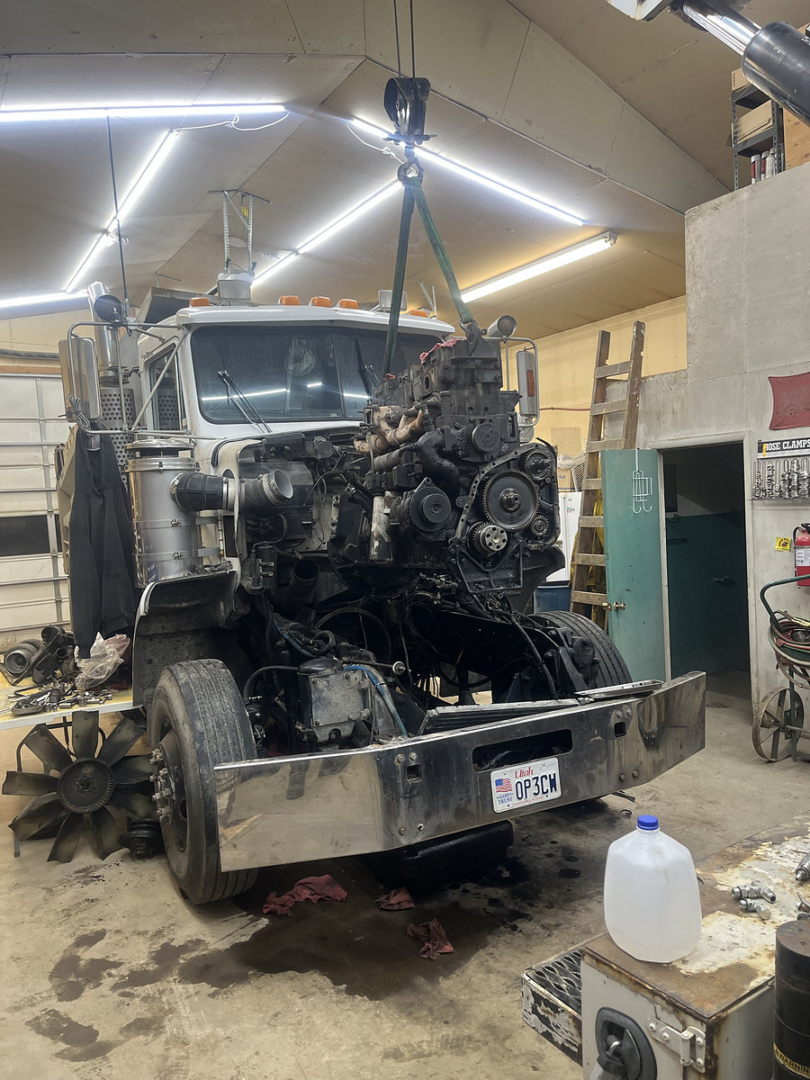 Engine being pulled from a truck in the shop